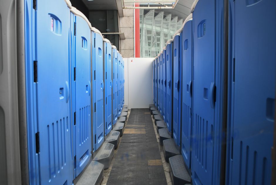 Cabines WC mobiles bleues alignées sur un site temporaire